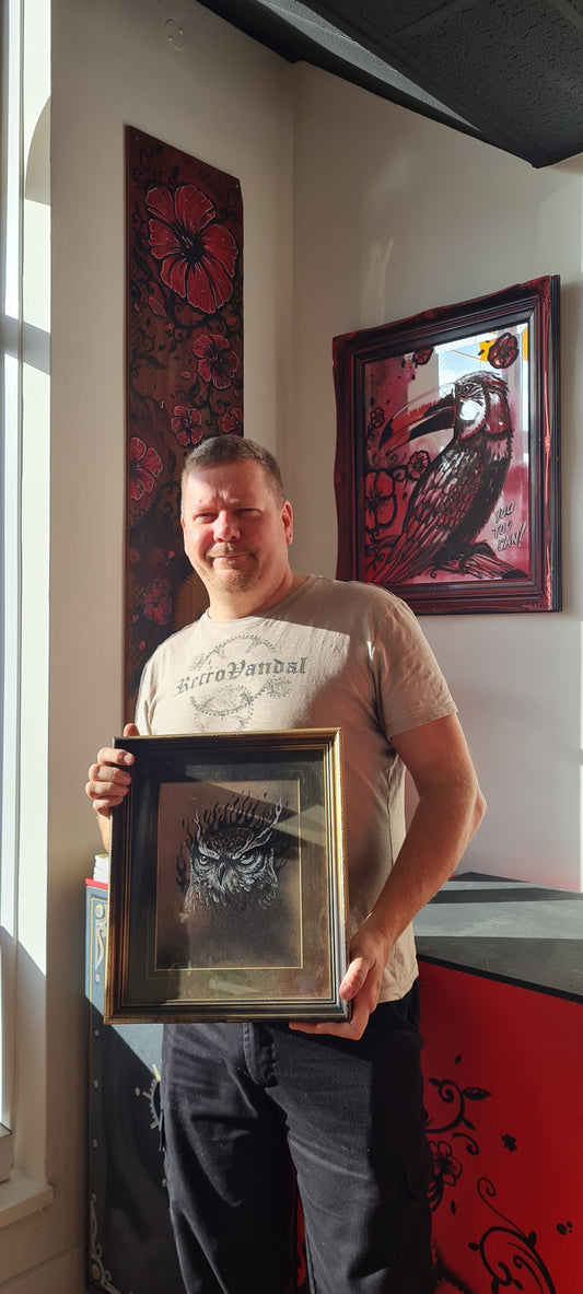 Retrovandal (Simon) standing in Peter's Place, which he helped decorate. He is also holding a frame illustration of his, featuring an owl.
